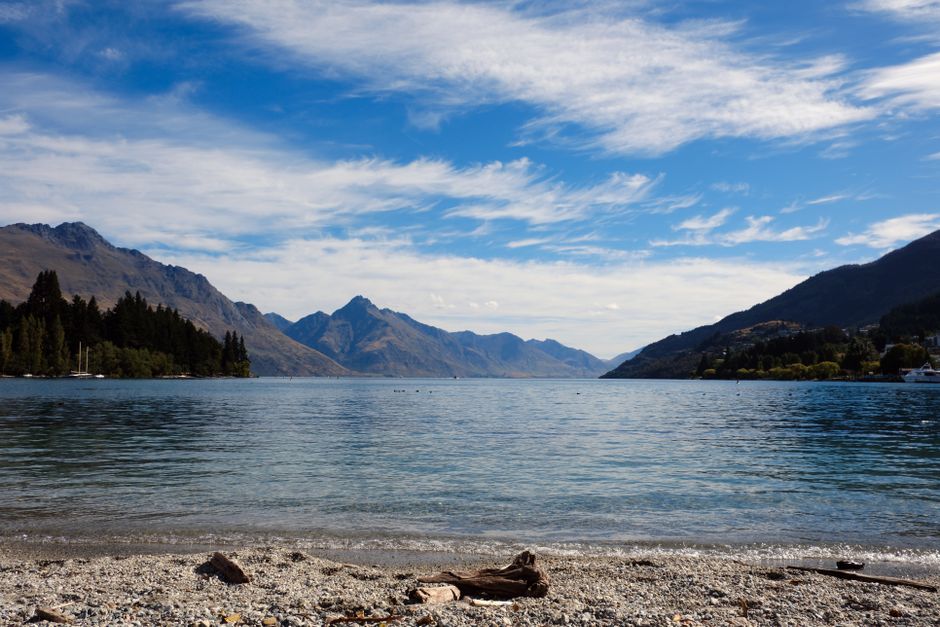 Tranquil views of Lake Wakatipu with surrounding mountains in Queenstown, New Zealand.