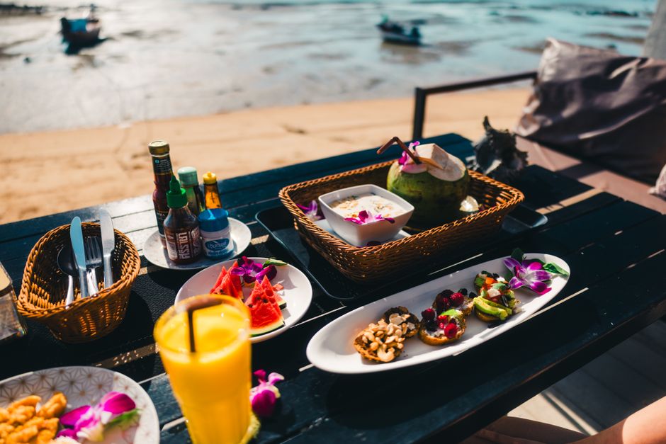 Experience exotic dining by the beach in Phuket with fresh tropical fruits and drinks.