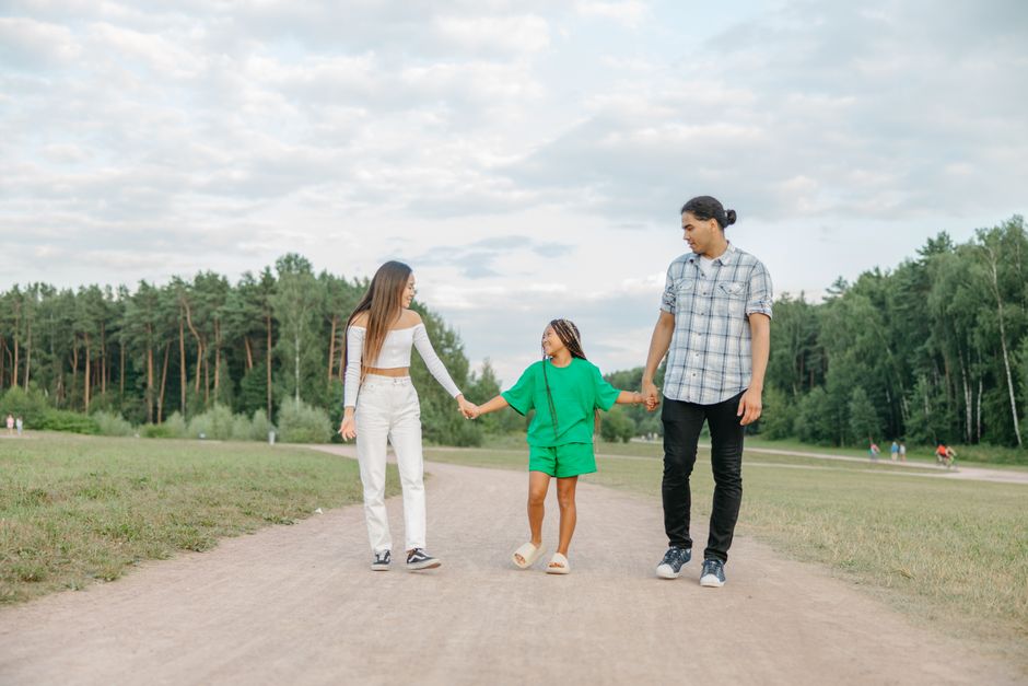Family bonding outdoors, walking and smiling on a sunny day.