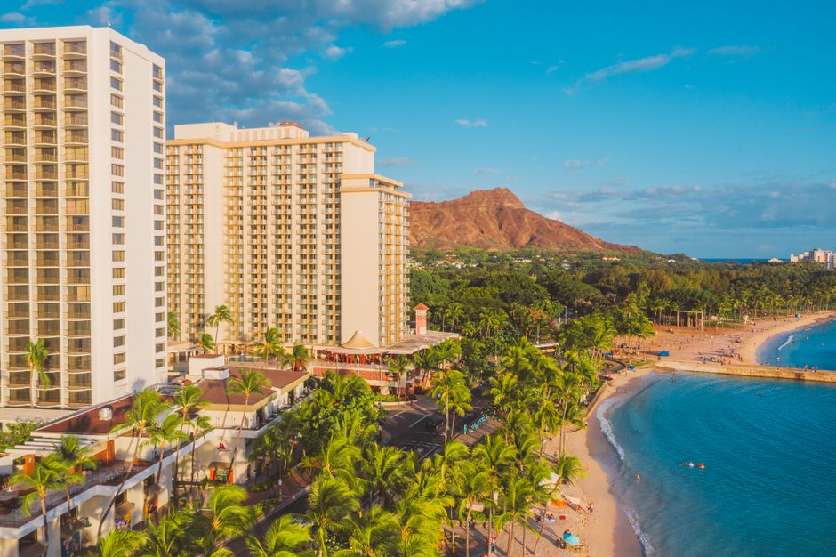Aerial view of Waikiki beach and luxury hotel with Diamond Head in background.