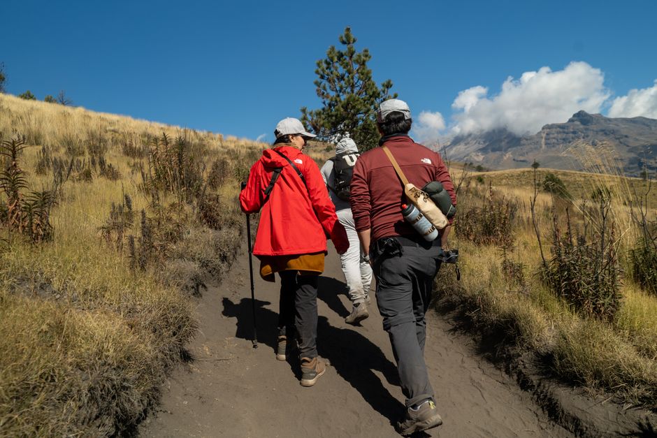 Group of hikers on a scenic mountain trail adventure with clear blue skies.