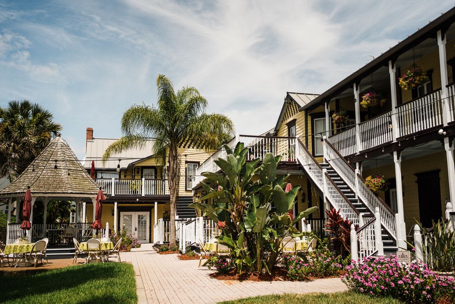 Charming courtyard with lush greenery and vibrant floral arrangements in historic St. Augustine, Florida.