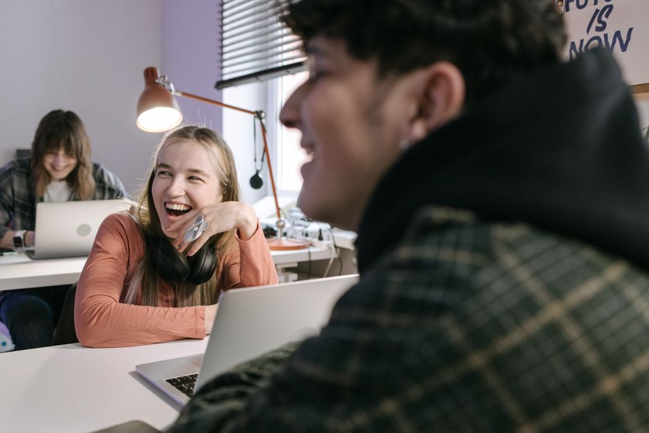 Adults collaborating and enjoying work in a shared office space, fostering creativity and connection.