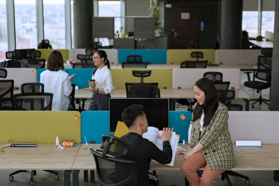 Dynamic office environment with team members engaged in collaboration and discussion.