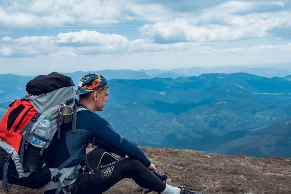 Hiker enjoys a serene mountain view, embodying adventure and wanderlust.