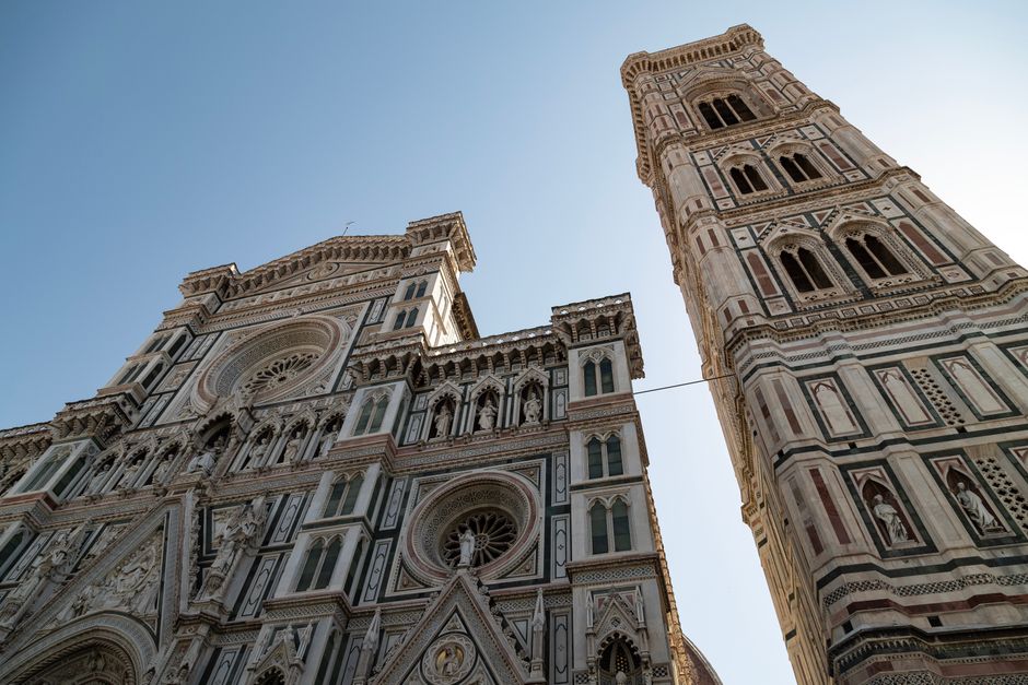 The striking facade of Florence Cathedral with intricate Gothic and Renaissance design under a clear sky.