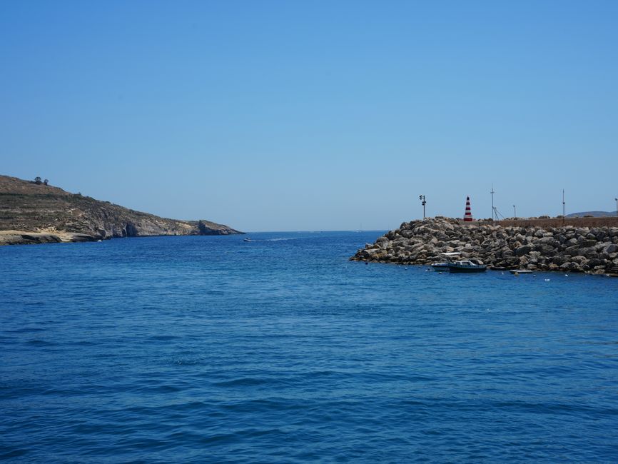 A calm Mediterranean seascape with a rocky coastline and clear blue waters in Malta.