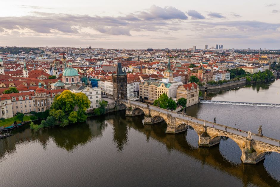 Stunning aerial shot of Charles Bridge crossing the Vltava River in Prague, highlighting historic architecture.