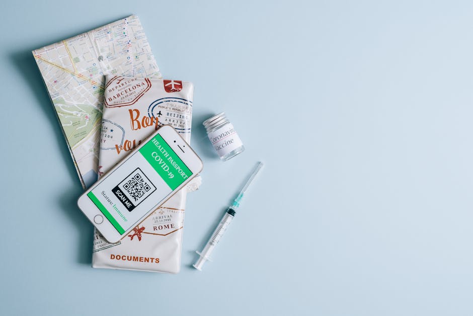 Vaccine and travel documents with COVID-19 health passport on smartphone. Essential travel preparation items.