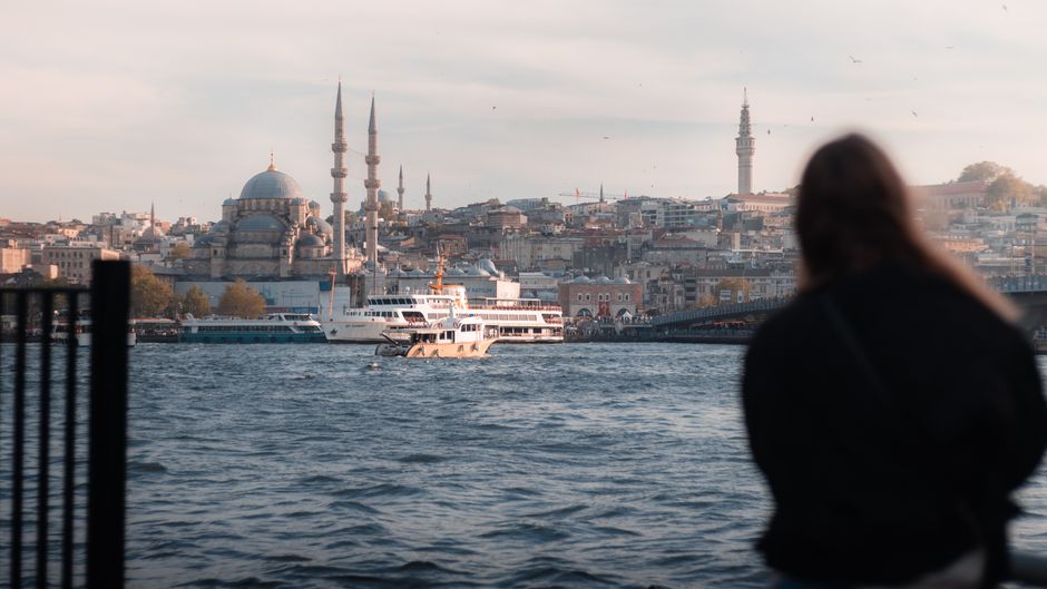A ferry sails on the Bosphorus with the Istanbul skyline and mosque in view.