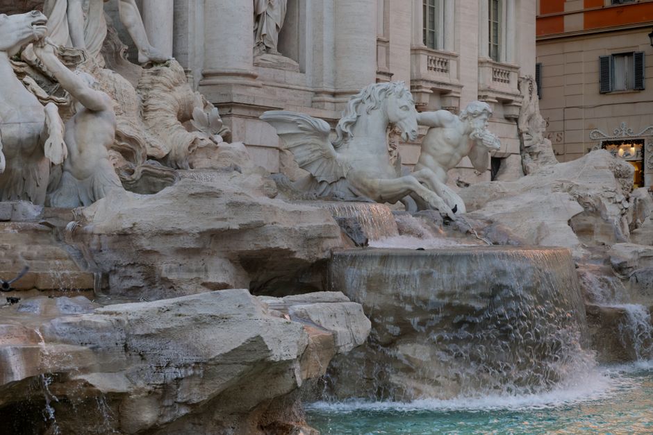 Close-up of Trevi Fountain's intricate Baroque sculptures and flowing water in Rome, Italy.